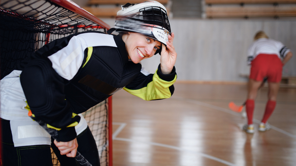 Eine junge Frau trägt unvernünftigerweise beim Feldhockey keinen Zahnschutz.