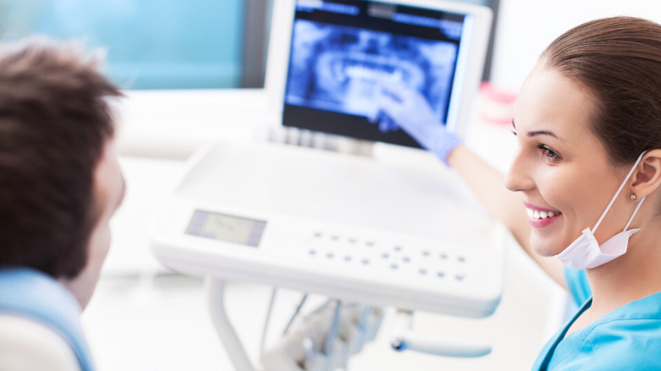 Eine Zahnärztin erklart dem Patienten ein Röntgenbild