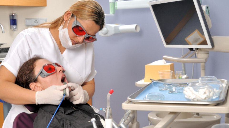 Eine Frau bekommt eine Laserbehandlung beim Zahnarzt