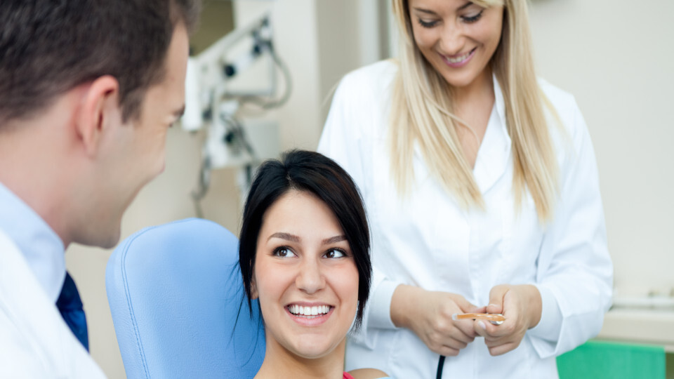 Eine lächelnde Frau auf dem Zahnarztstuhl