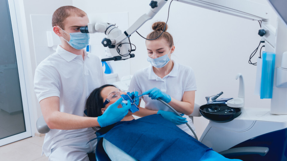 Ein Zahnarzt führt bei einer Patientin eine Wurzelbehandlung durch