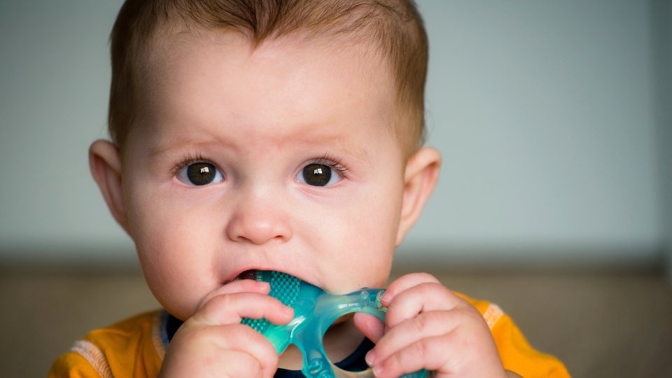Ein Baby kaut auf einem Beißring 