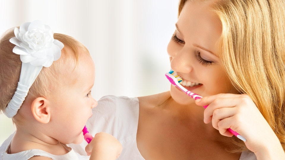 Eine Mama putzt mit ihrem Baby die Zähne
