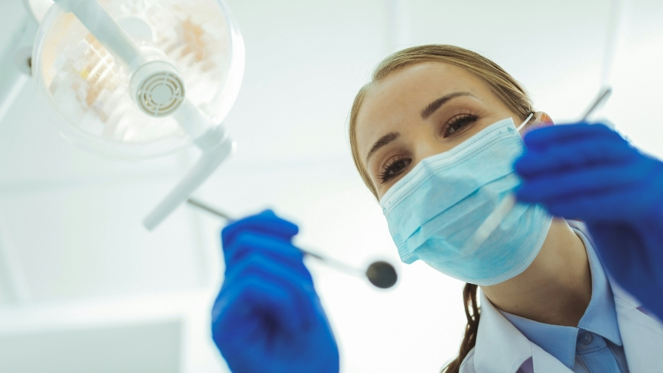 Eine Zahnärztin beugt sich über einen Patienten